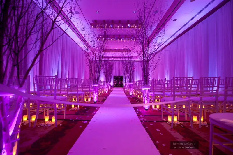 Ceremony aisle washed in violet uplighting