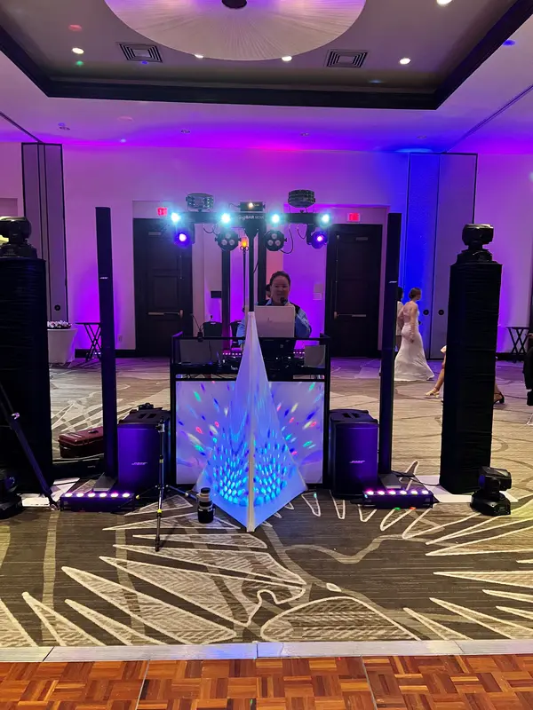 Chris James DJ setup with violet uplighting at a ballroom reception