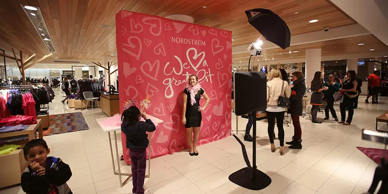 Photo booth set up with a patterned red backdrop at an event
