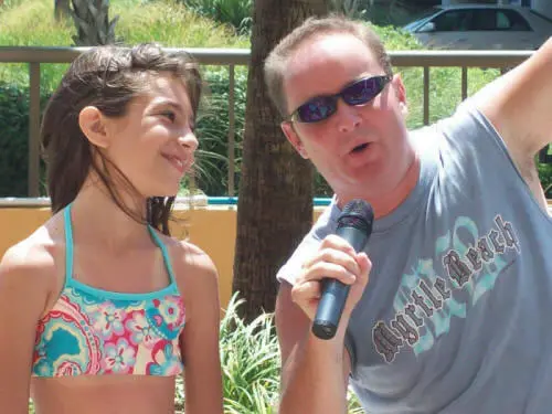 Chris James with the microphone and a young contestant
