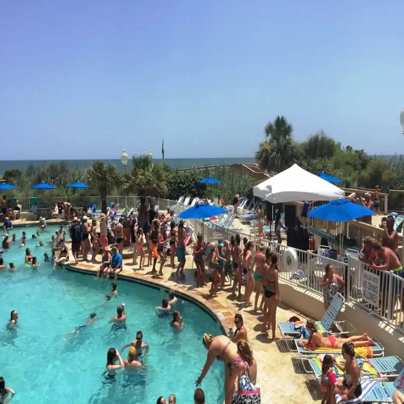 Packed resort pool deck on a sunny day